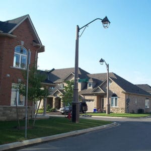 A K601D Coach fixture accompanied by a Coach Lantern style arm on top of an Alexander pole.