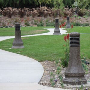 Multiple lit Belmont style bollards finished with one of our signature concrete décor colors – Midnight Lace.