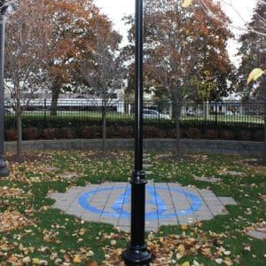 A black aluminum pole with a round non-tapered cross section accompanied by a decorative base plate. This project is in Burlington, Ontario at StressCrete's headquarters.