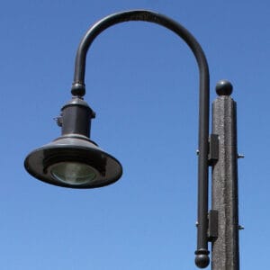 A K723 Falconridge Jr. fixture accompanied by a Bishop Crook style arm on top of a Fluted Tapered pole.