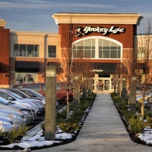 Multiple lit Martello Square style bollards finished with one of our signature concrete décor colors – Pearl Gray. This project is located outside of a Hockey Life in Kitchener, Ontario.