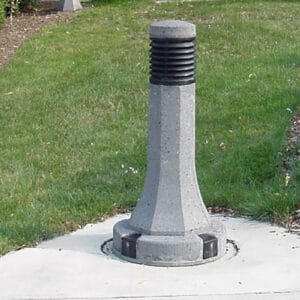 A lit Sheridan style bollard finished with one of our signature concrete décor colors - Salt and Pepper.