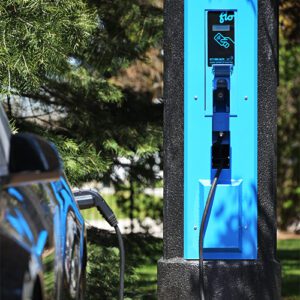 A black car utilizing some of the features offered by the VoltLock EV Charger pole.