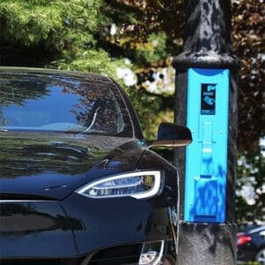 A black car utilizing some of the features offered by the VoltLock EV Charger pole.