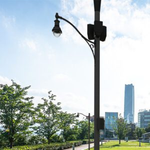 A K201 Radian fixture accompanied by a decorative scroll style arm on top of a Round Non-Tapered (Small Cell) pole.