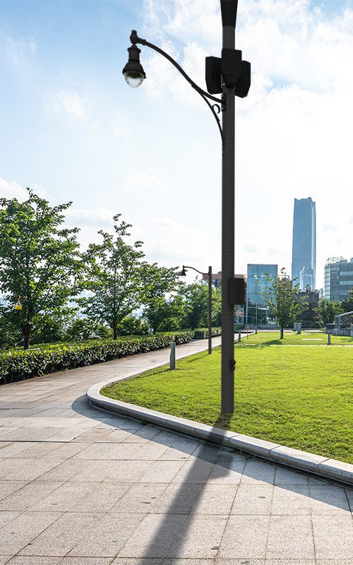 A K201 Radian fixture accompanied by a decorative scroll style arm on top of a Round Non-Tapered (Small Cell) pole.