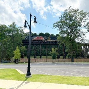 Two K804 Coronet Sr. fixtures accompanied by KA32 Pipe arms atop a fluted tapered pole with a KSB20 Cleveland Sr. split base.