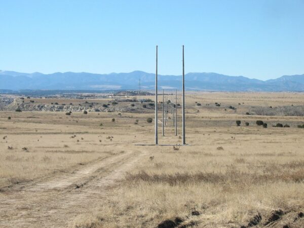 Spun concrete utility poles with a 'tangent' application. This project is in a flat, remote area with mountains in the background.