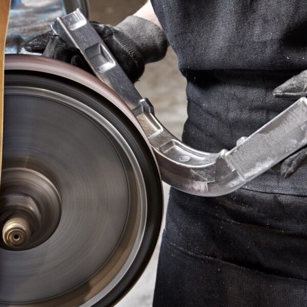 An employee at King Cast grinding away excessive materials from a metal casting.
