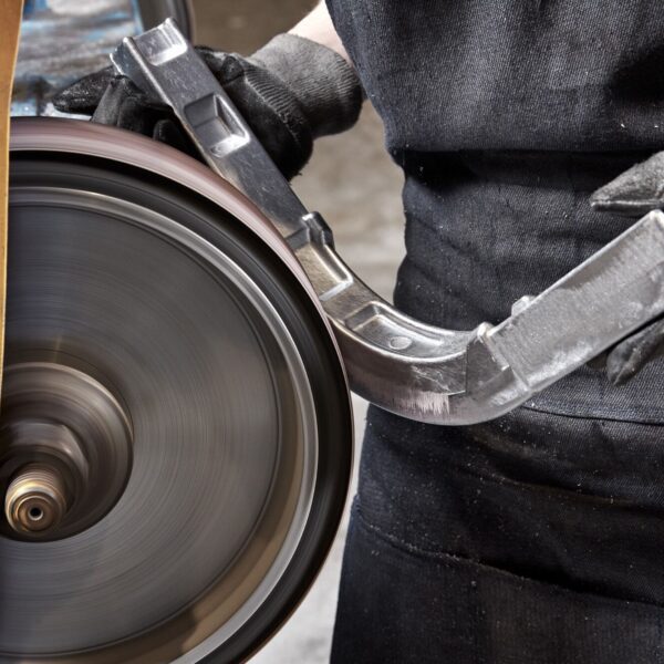 An employee at King Cast grinding away excessive materials from a metal casting.