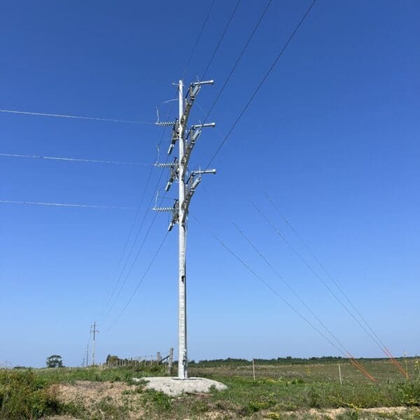 A spun concrete utility pole with an 'angle' application. This project is in a flat, grassy area.