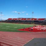 Multiple Spartan sports lighting poles overlooking a football field and track. Project is at Laval University in Laval, Quebec.