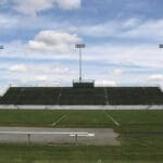 Multiple Spartan sports lighting poles overlooking a football field.